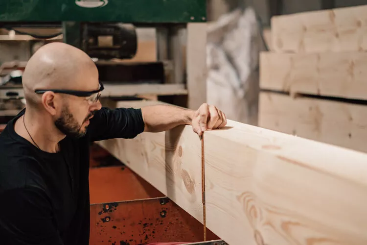 Alex Skarshelg measuring a timber beam