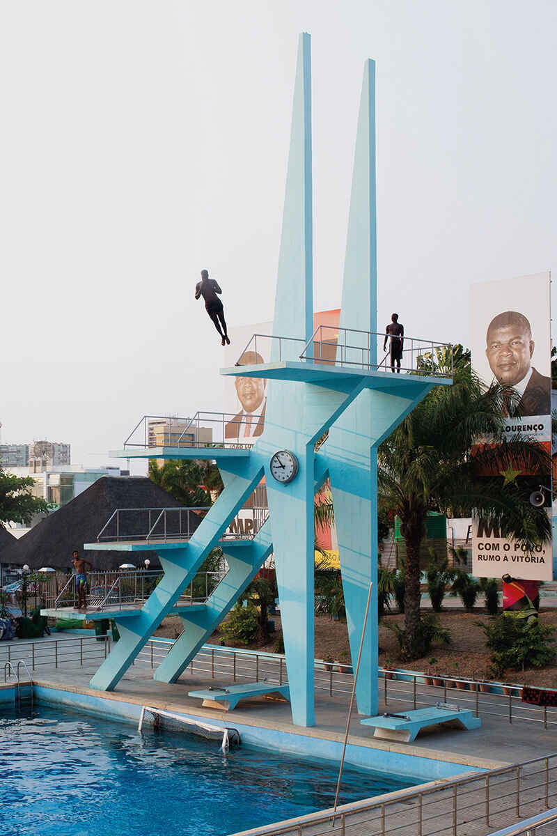 Men diving from a blue diving board structure