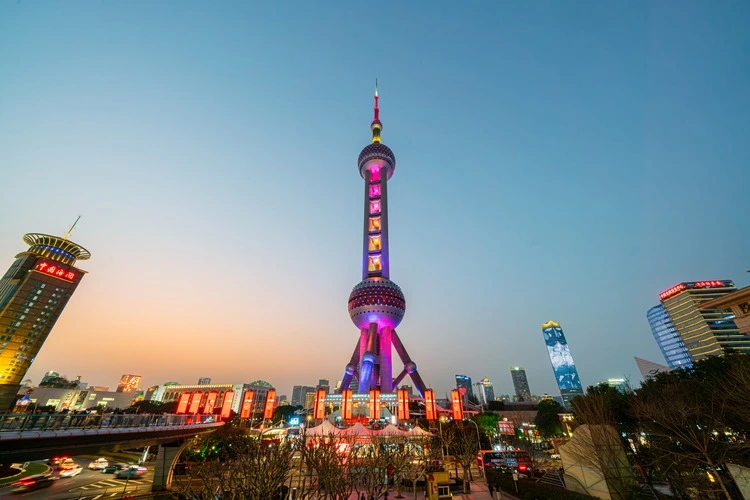 Shanghai, China - March 16th 2024: Busy traffic road with The Oriental Pearl Tower at night