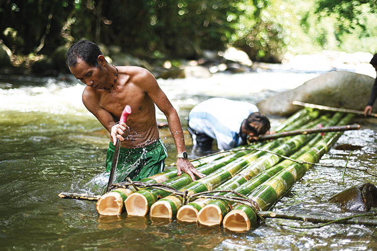 Villagers make a bamboo raft to transport goods to other villages