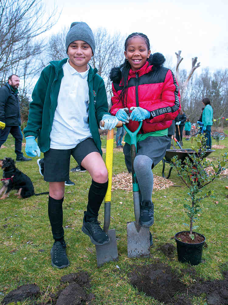 Children from Rushmore Primary School in Hackney plant trees in a local park