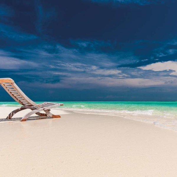 Tourism: sunlounger on a white sand beach