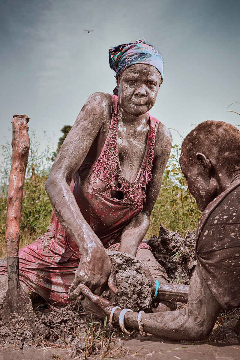 Nyanong, 44, tries to repair a broken dyke protecting the village of Pankir