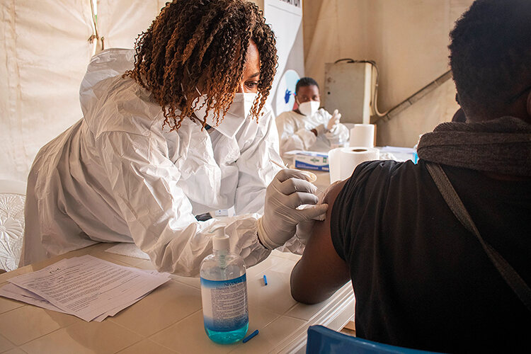 A health worker in Rwanda administers a vaccine