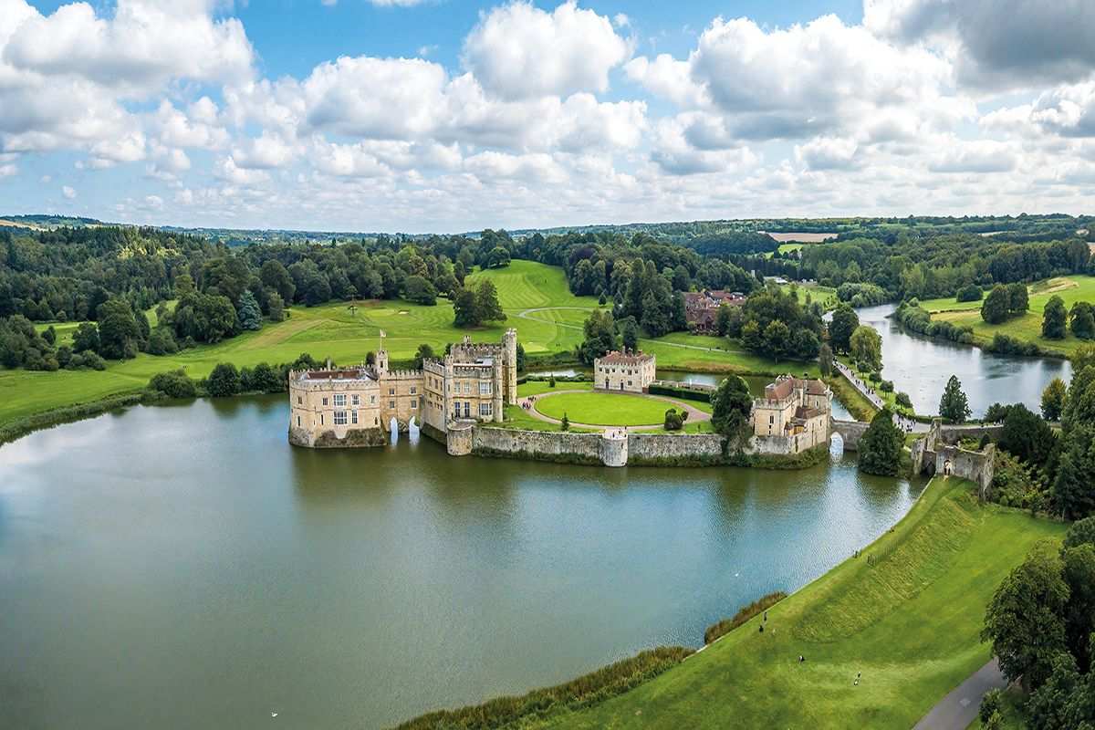 Leeds castle on a lake surrounded by trees 