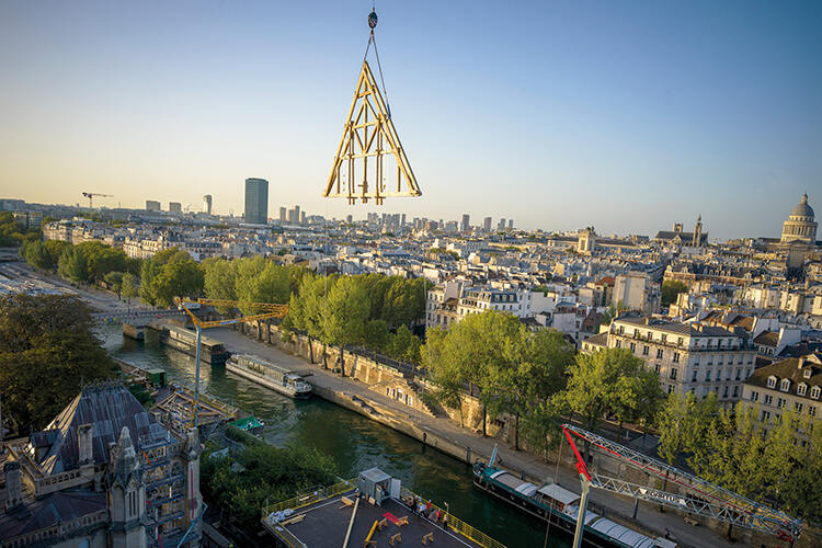 Notre Dame frame being lifted into place above the Paris skyline