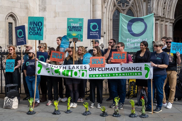 South Lakes Action on Climate Change (SLACC) and Friends Of The Earth holding signs outside High Court.