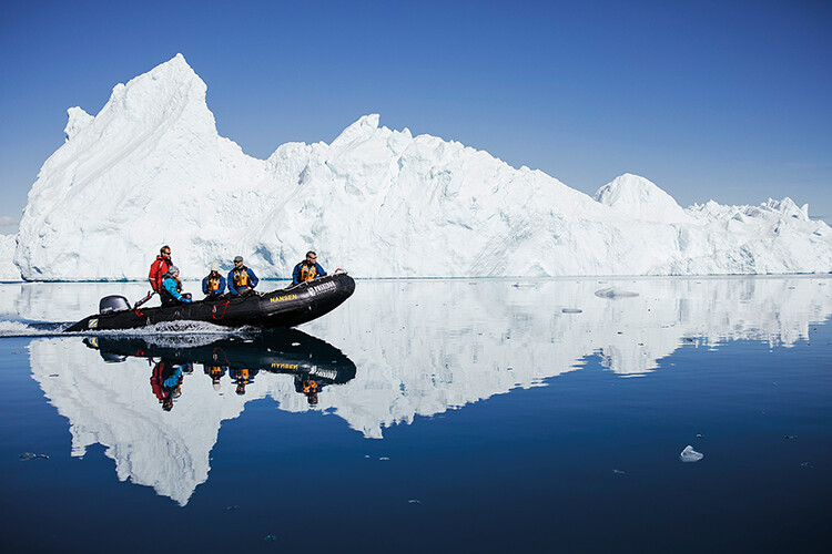 Lewis-Jones (in red) drives a zodiac off the west coast of Greenland