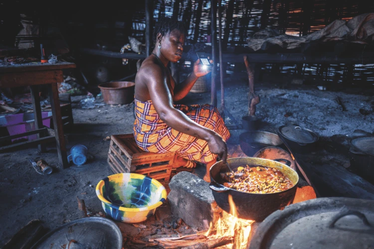 Gaya Bang, 35, driven out of previous homes by flooding, prepares a meal in her new shelter on Nyangai Island