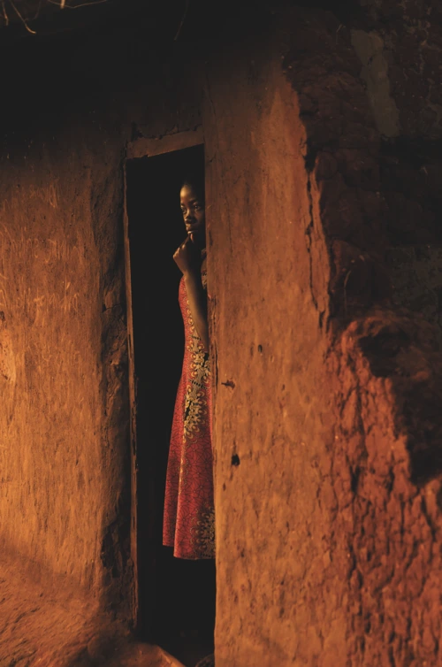 Jacqueline Aron, 14, stands in the doorway of the kitchen while she waits for the water for a bath to heat up ahead of going to school