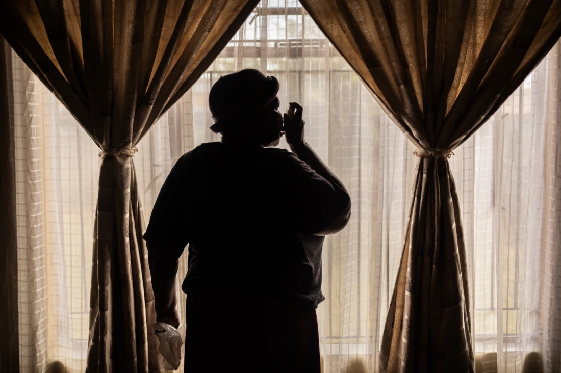 Maria Nkosi demonstrates how she uses her inhaler for her asthma, at her home, which is a street away from a mine in Clever, Witbank, Emalahleni