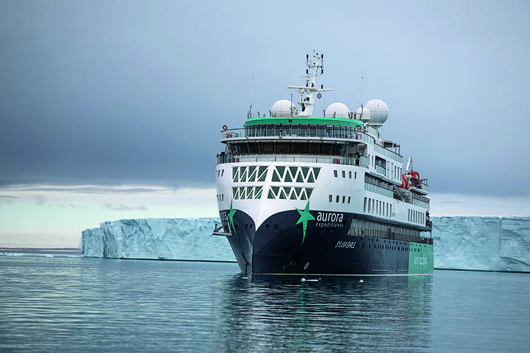 The boat 'Sylvia Earle' moored in front of icy cliffs