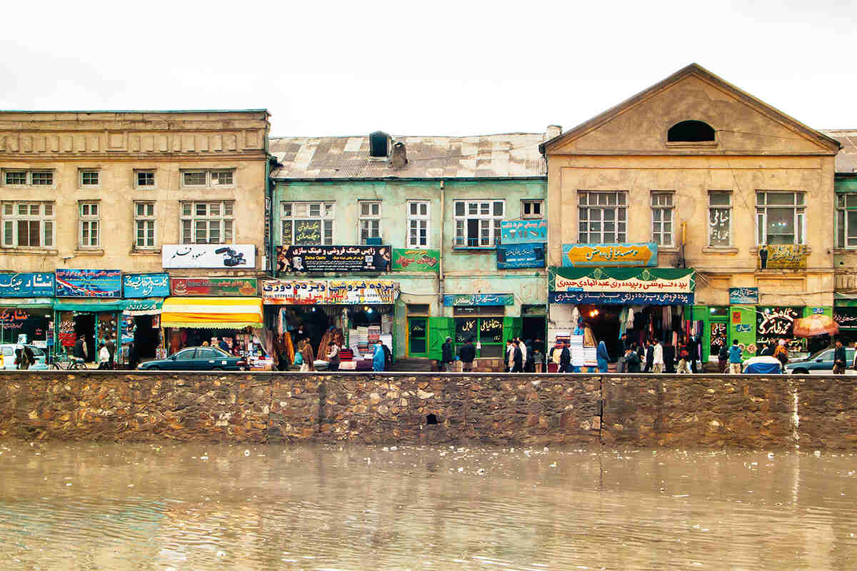 Kabul river embankment with a busy street and shops