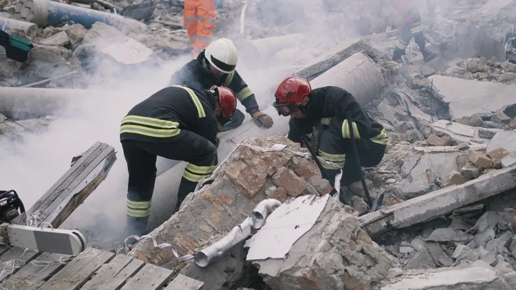 Emergency workers removing rubble together