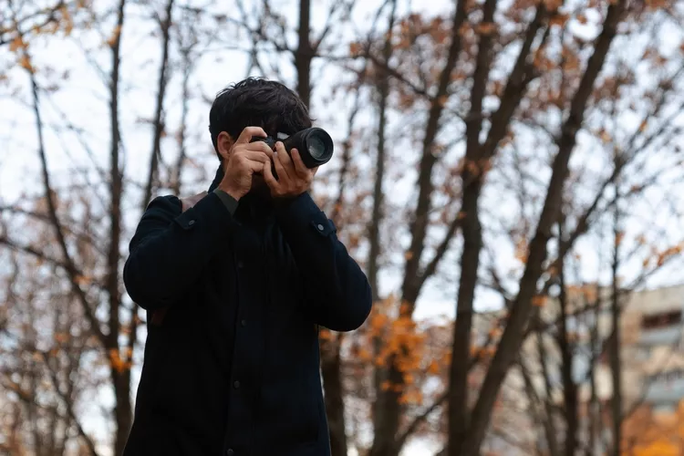 Photographer Capturing Autumn Scene in Park

