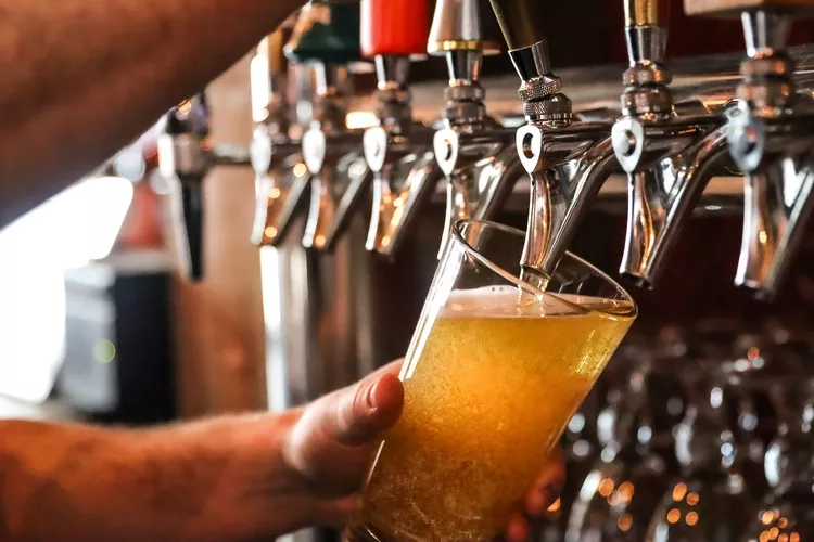 Closeup of bartender pouring fresh beer from tap.