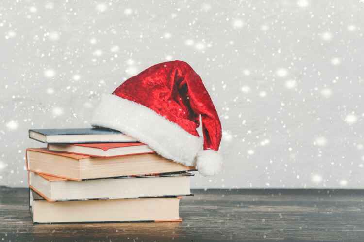 A pile of books topped with a Father Christmas hat