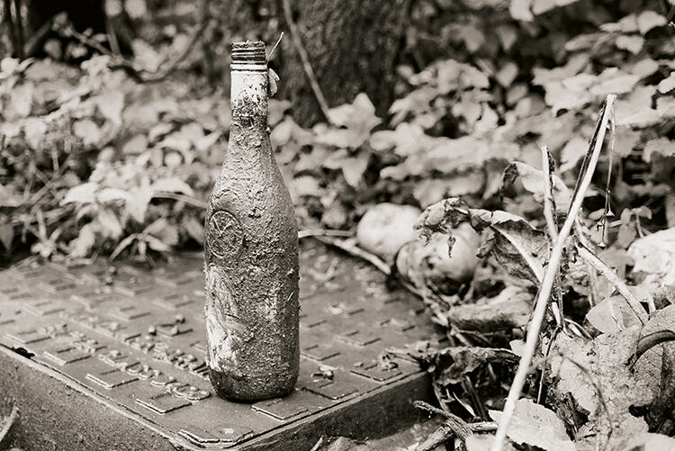 Wine bottle and drain cover: a modern still life