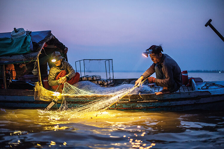 Meng Thy (left) and Veng Yung haul in their nets, searching them in vain for fish