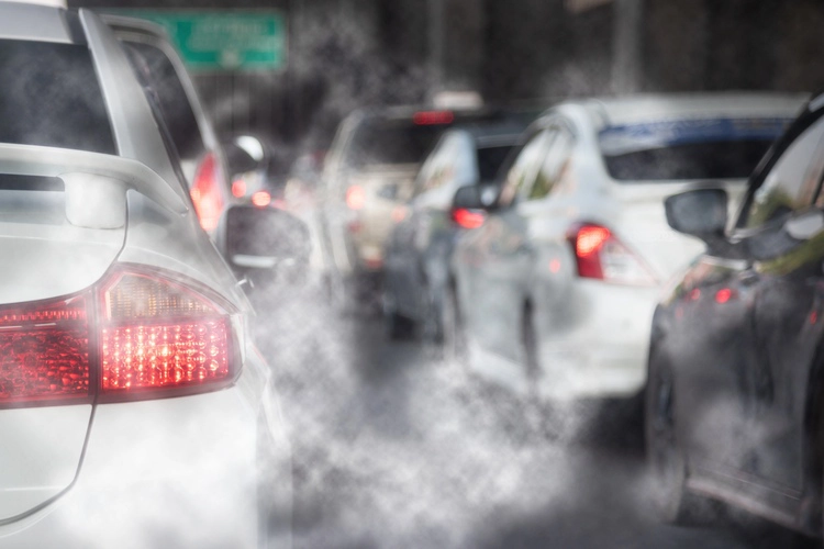 Close up views of cars with exhaust fumes coming out of their exhausts.