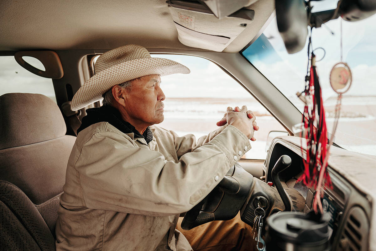 A man sits in a truck looking out at the water levels