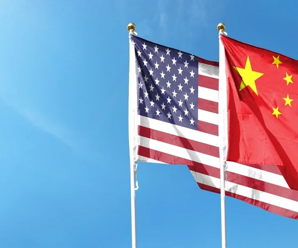 American flag and Chinese flag on cloudy sky
