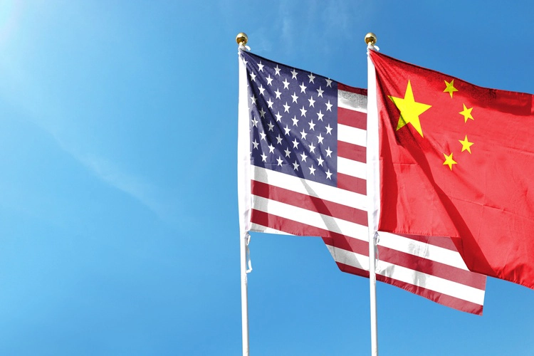 American flag and Chinese flag on cloudy sky