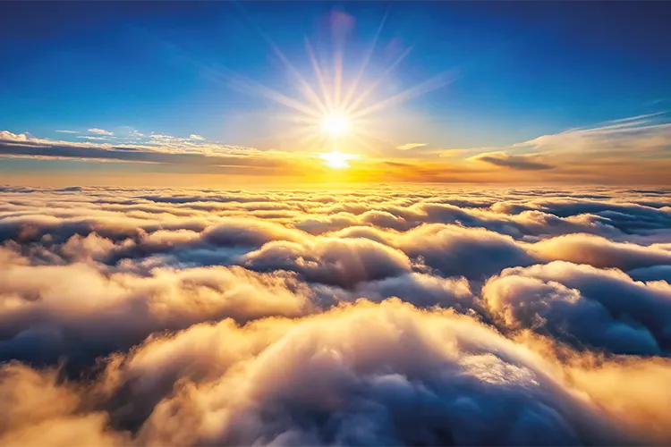 Glowing clouds below sun during sunrise