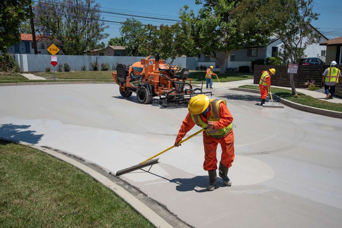 Workers paint grey streets white with solar-reflective paint
