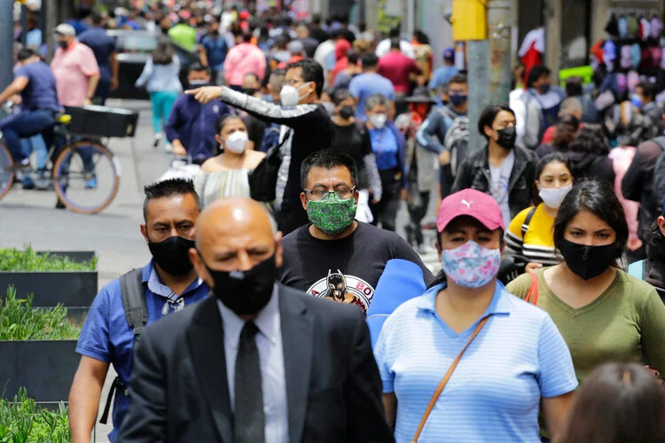 Mexico City, Mexico - August 14, 2021: People wear face masks to protect from Coronavirus, COVID-19 pandemic, as they walk by a street in downtown CDMX.