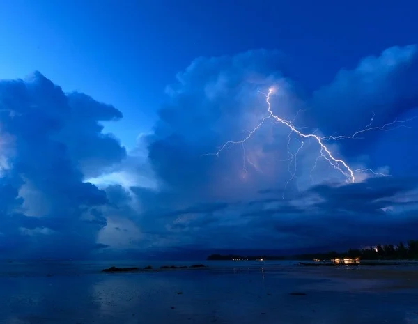 Lightning from a cumulonimbus thunder cloud strikes a tropical beach