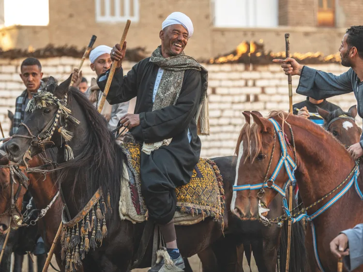 Horsemen in traditional dress ride at the Mermah festival in Dandara