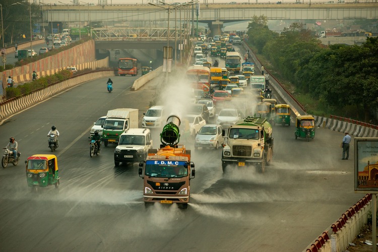 New Delhi, India-23 Nov 2021: A municipal truck uses anti smog gun to spray water on the road for dust suppression to reduce air pollution in delhi.