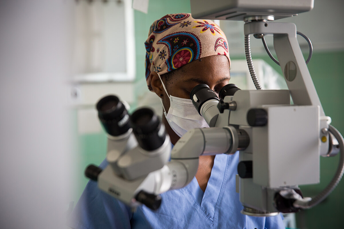 A female doctor in South Africa looks through a microscope 