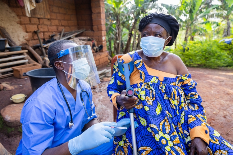 The village doctor visits a sick old woman and gives her an injection.