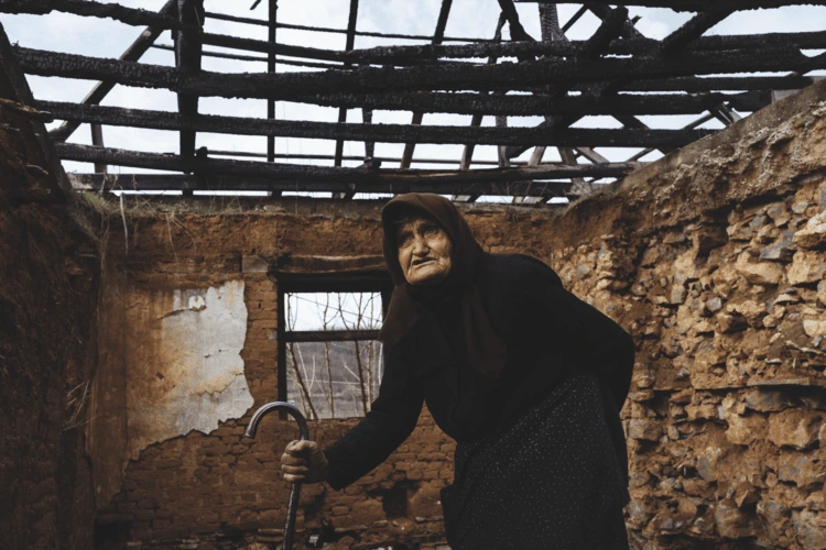 An elderly woman in a derelict building in the Serbian enclave of Velika Hoča