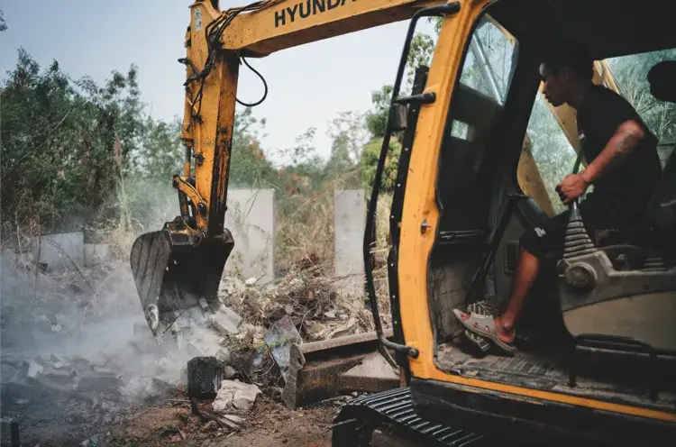 Using an excavator to clear
the area before searching
for landmines by hand
