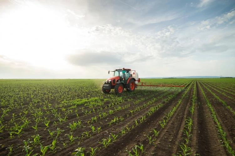 Tractor spray fertilize field with insecticide herbicide chemicals in agriculture field