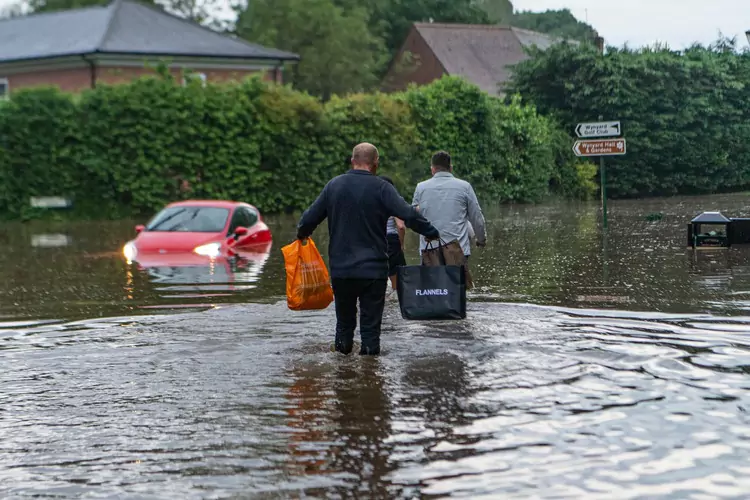 Wynyard, County Durham, UK: People are seen wadding back to their homes in Wynyard, County Durham this evening as heavy bank holiday rain showers caused flash flooding