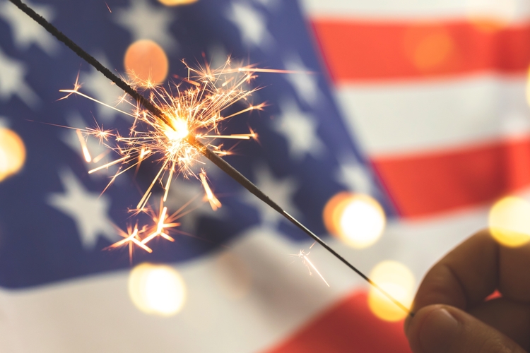 US flag with sparkler in front of it