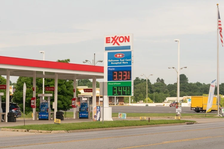 Waynesboro, VA US - July 2, 2023: Exxon retail gas station seen from across the street with digital fuel price per gallon on display on a large sign board thats common in the US