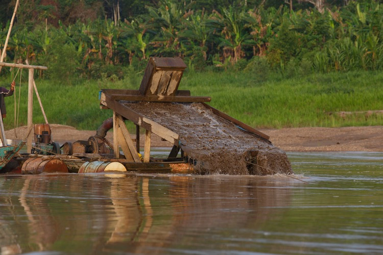 Gold dredging equipment in the Amazon River, Peru. This image highlights the environmental impact of illegal mining in the rainforest, a major threat to ecosystems