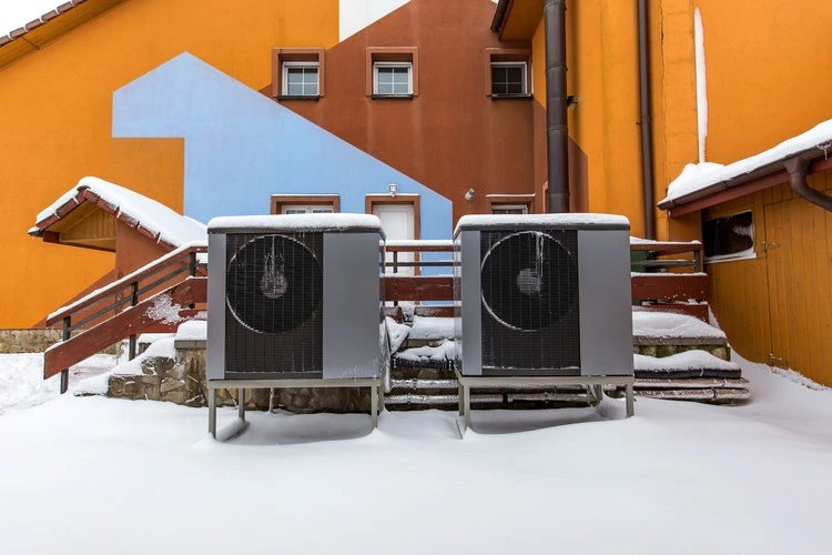 Two residential modern heat pumps buried in snow