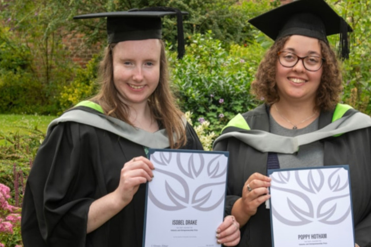 Isobel and Poppy holding graduation certificates