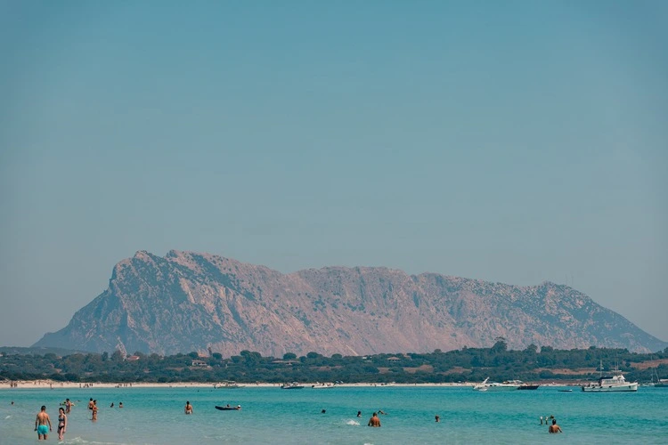 
San Teodoro, Italy - 25 July, 2022 - Turquoise waters of Tyrrhenian Sea and Isola Tavolara (island) in the distance, seen from Spiaggia La Cinta, Costa Smeralda, Sardinia