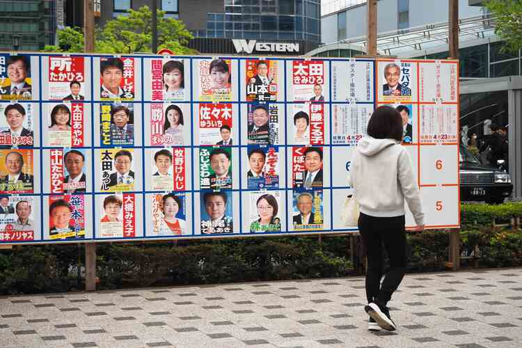 
TOKYO, JAPAN - April 22, 2023: Official election poster board on a street in Nishi Kasai area with posters of Edogawa Ward local election candidates.