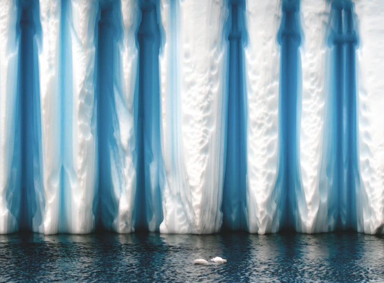 A wind-carved iceberg floats near the Antarctic Peninsula