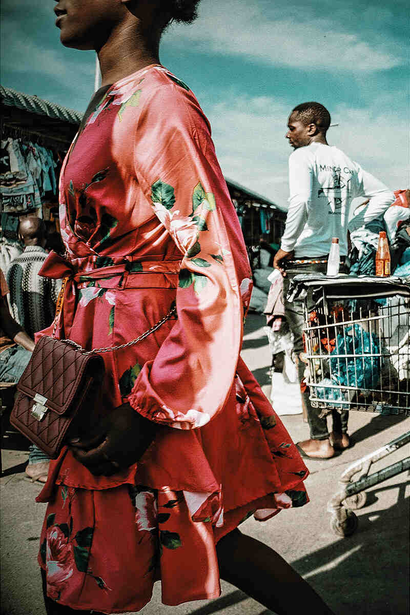 A woman in a pink dress in a busy market 