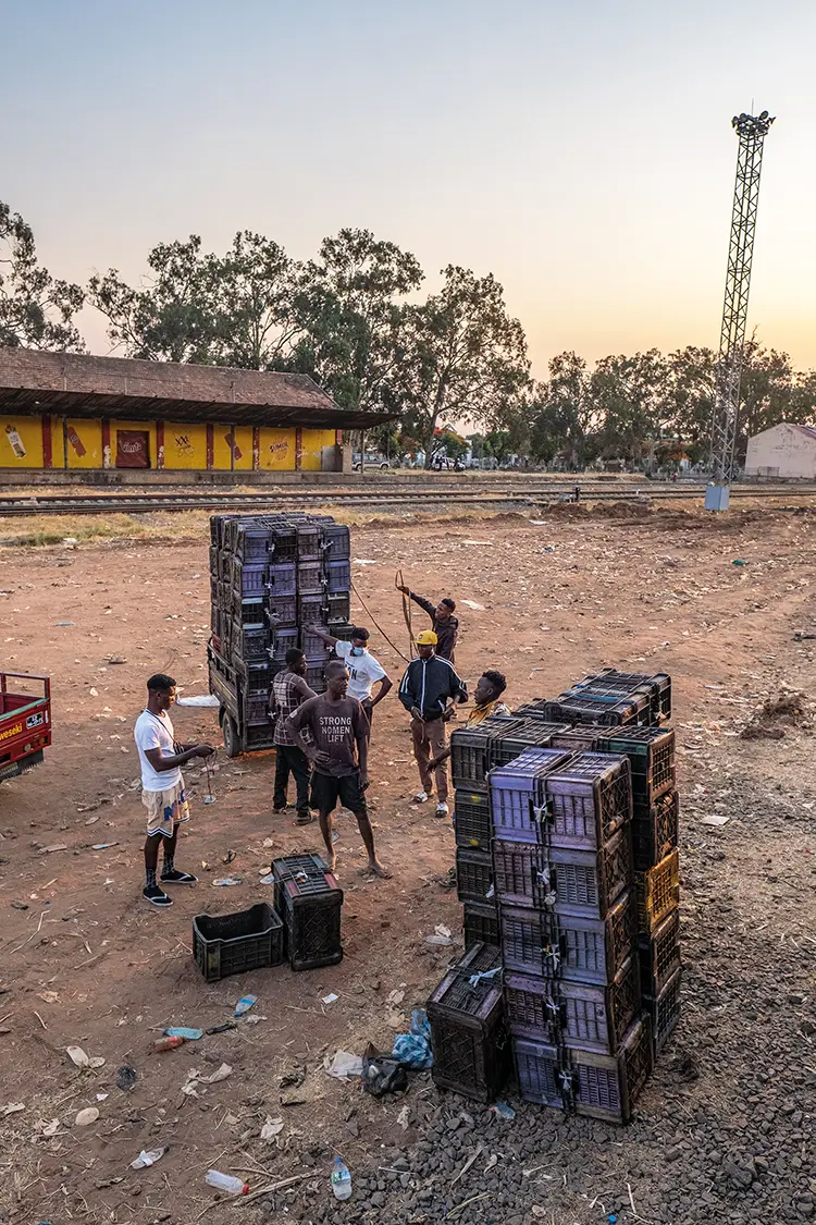Workers prepare to load cargo onto a train at Luena
