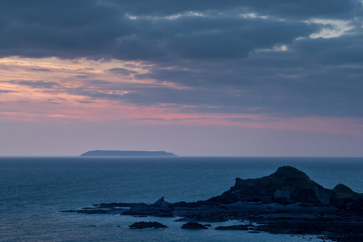 Sunset view of Lundy island from Hartland beach. Devon, UK.